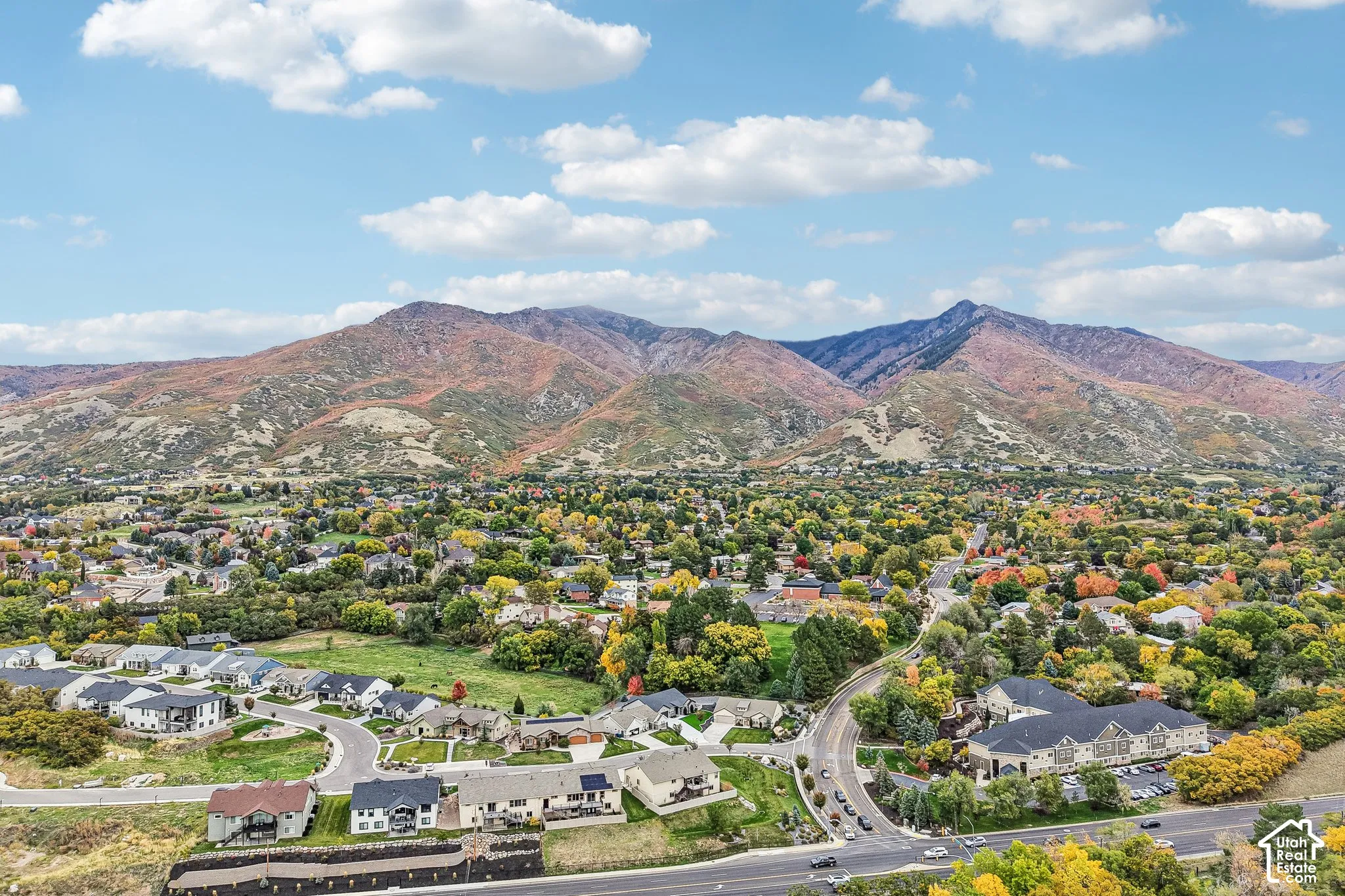 Aerial perspective featuring expansive mountain topography and mature tree canopy throughout the residential landscape