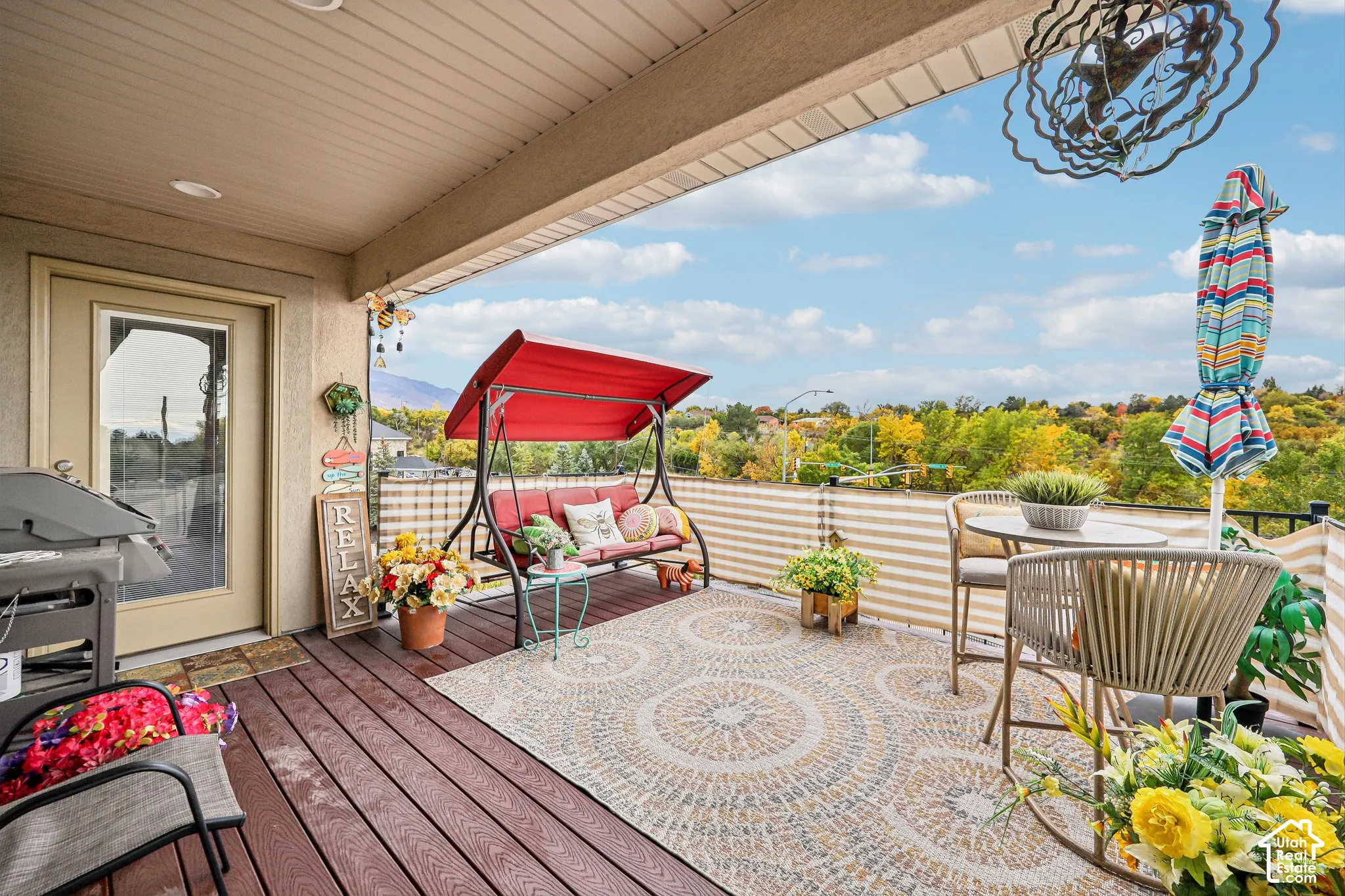 Covered balcony featuring wood-finish decking, a metal railing, recessed ceiling lighting, and expansive scenery