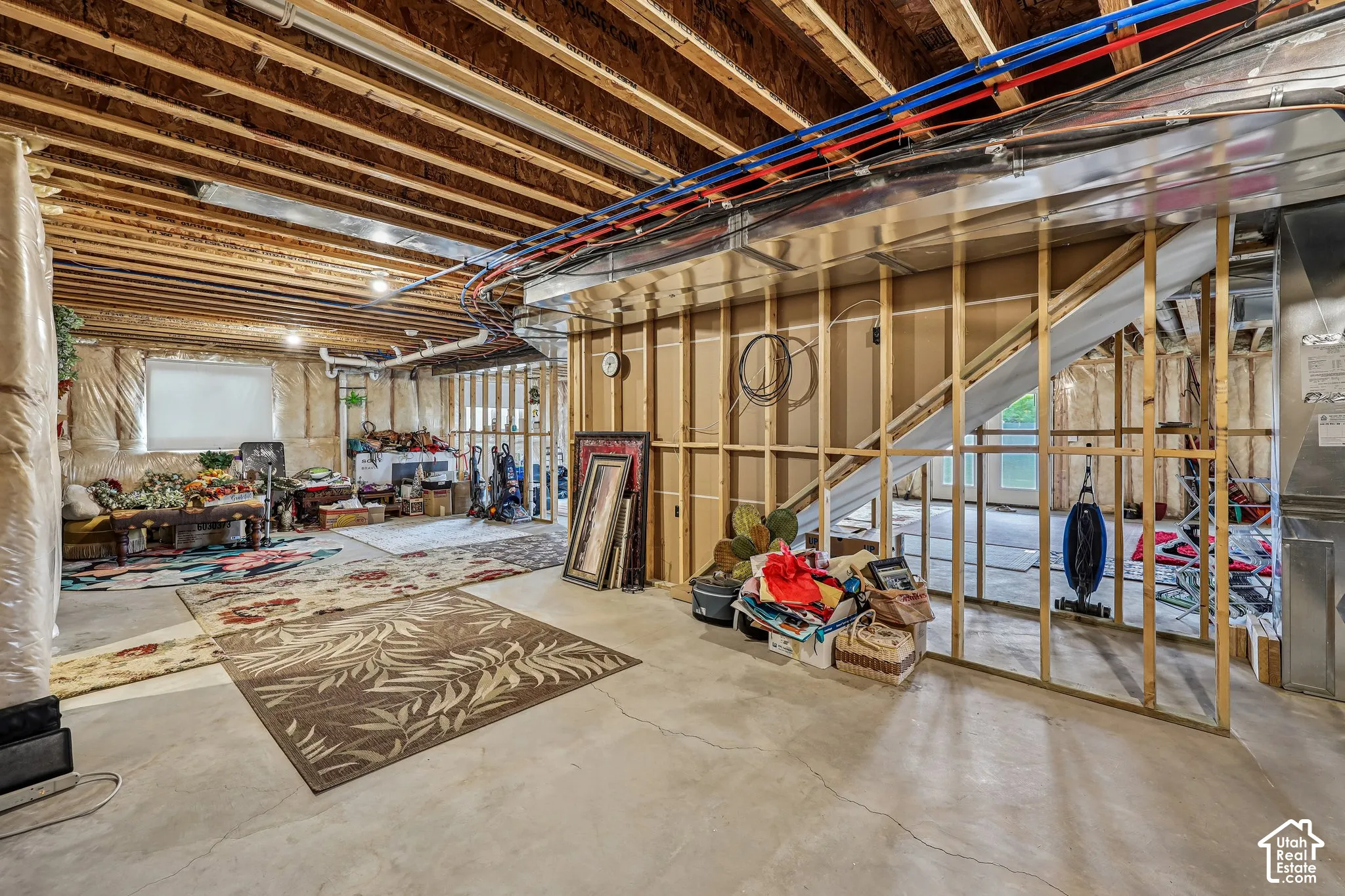 Unfinished lower level featuring exposed wood joists, concrete flooring, and plumbing infrastructure
