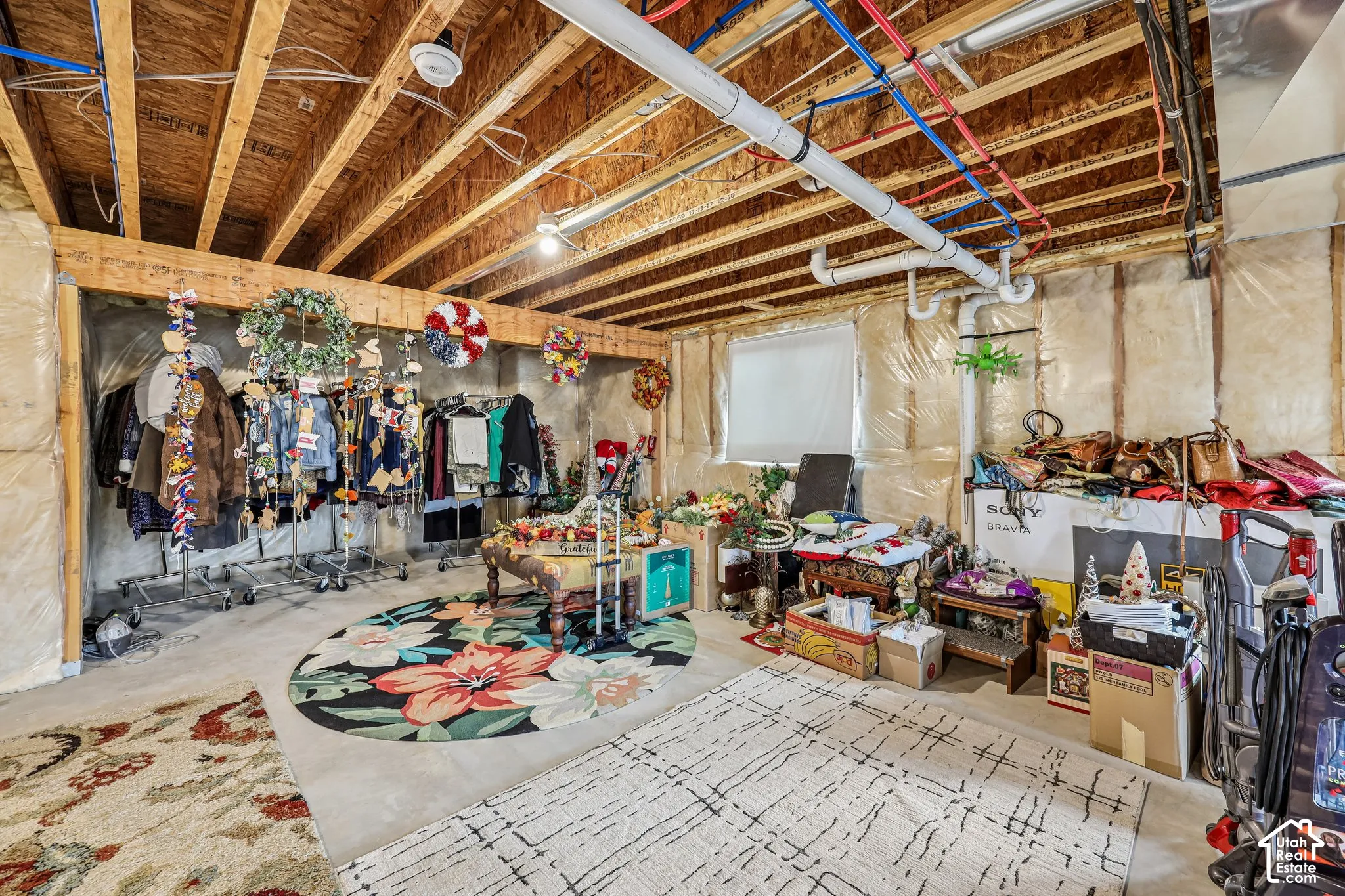 Unfinished basement featuring exposed joists, concrete flooring, and perimeter wall insulation