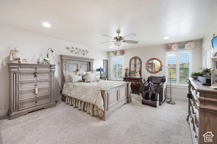 Neutral-toned room featuring recessed lighting, a brushed metal ceiling fan, and adjustable louvered shutters
