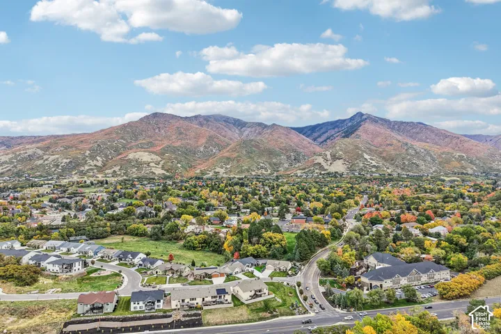 Aerial perspective featuring expansive mountain topography and mature tree canopy throughout the residential landscape