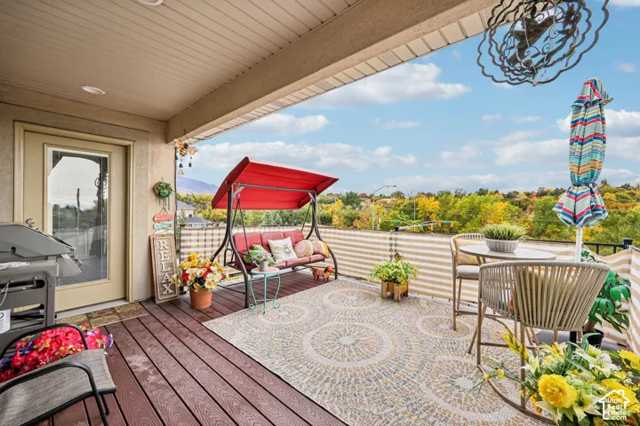 Covered balcony featuring wood-finish decking, a metal railing, recessed ceiling lighting, and expansive scenery