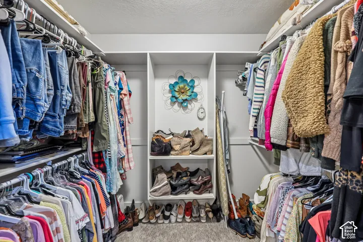 Walk-in closet featuring multi-level clothing rods and built-in central shelving units