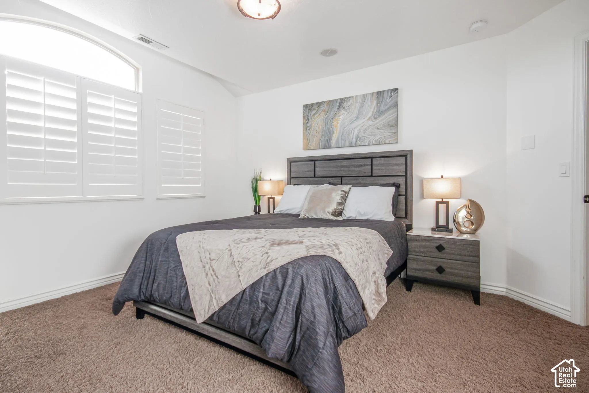 Interior space featuring arched window detailing, plantation shutters, and a ceiling-mounted light fixture
