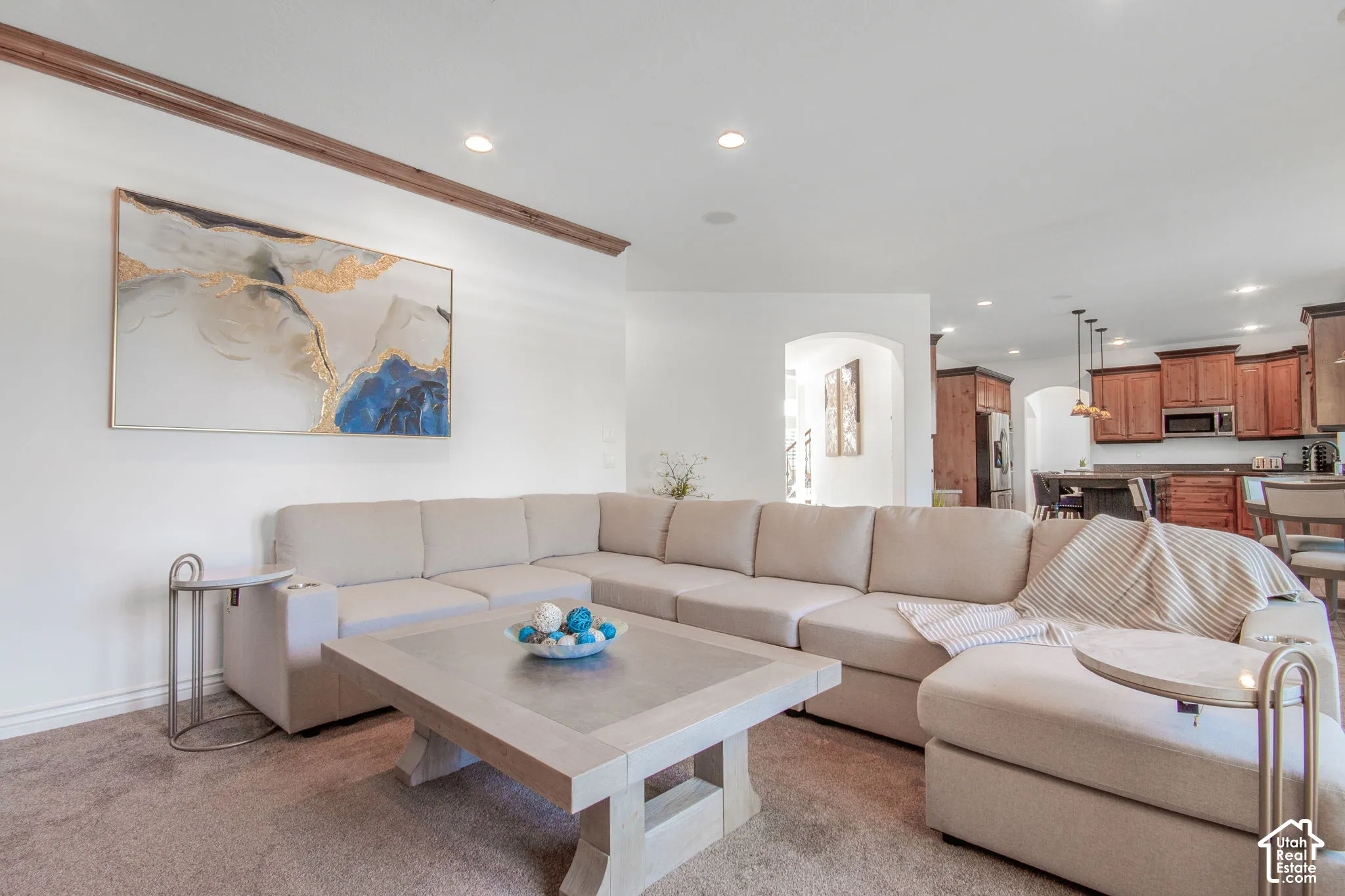 Open living area featuring crown molding, recessed lighting, and arched entries