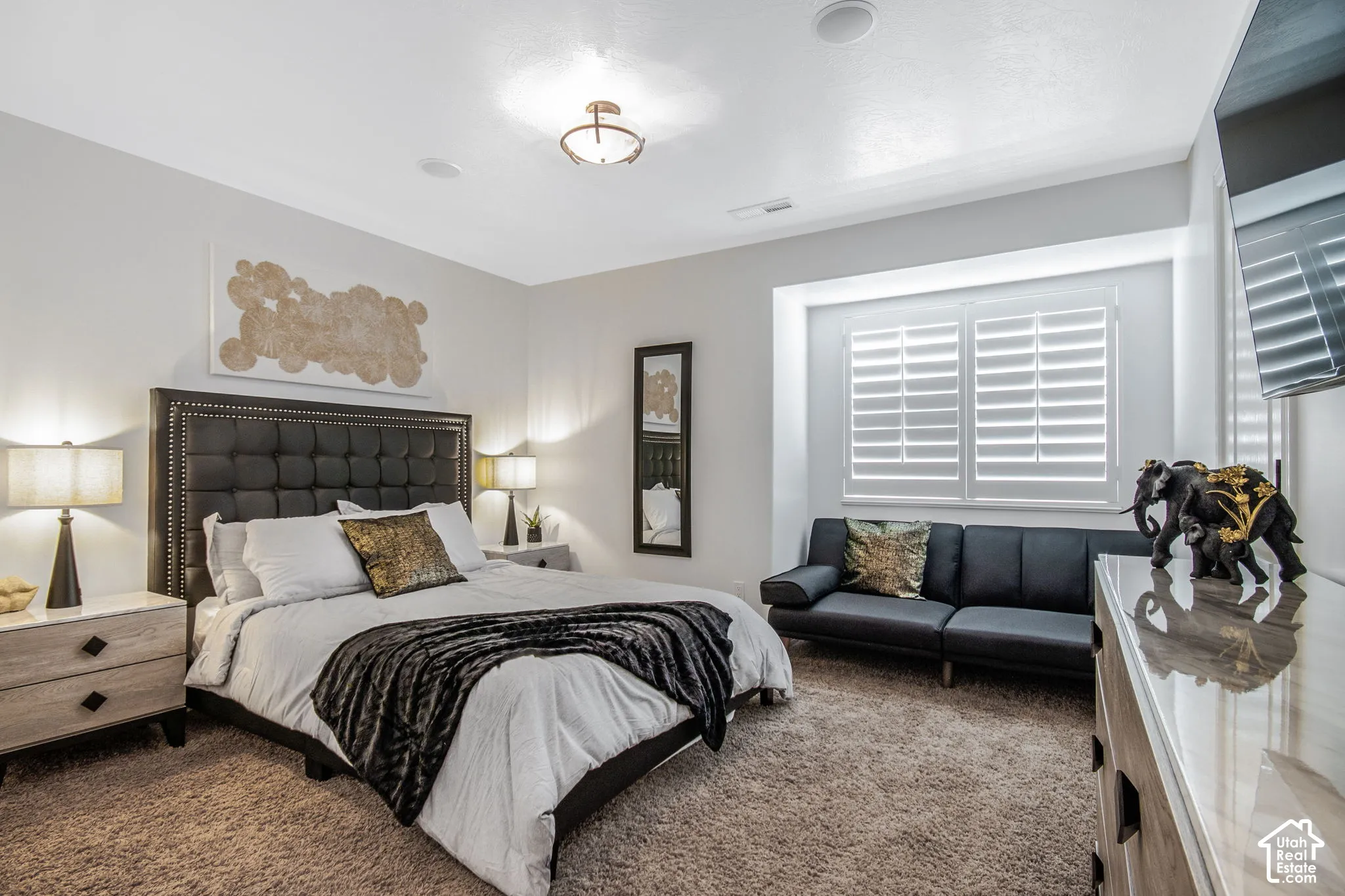 Neutral-toned interior featuring plush carpeting, recessed ceiling lighting, a flush-mount light fixture, and plantation shutters