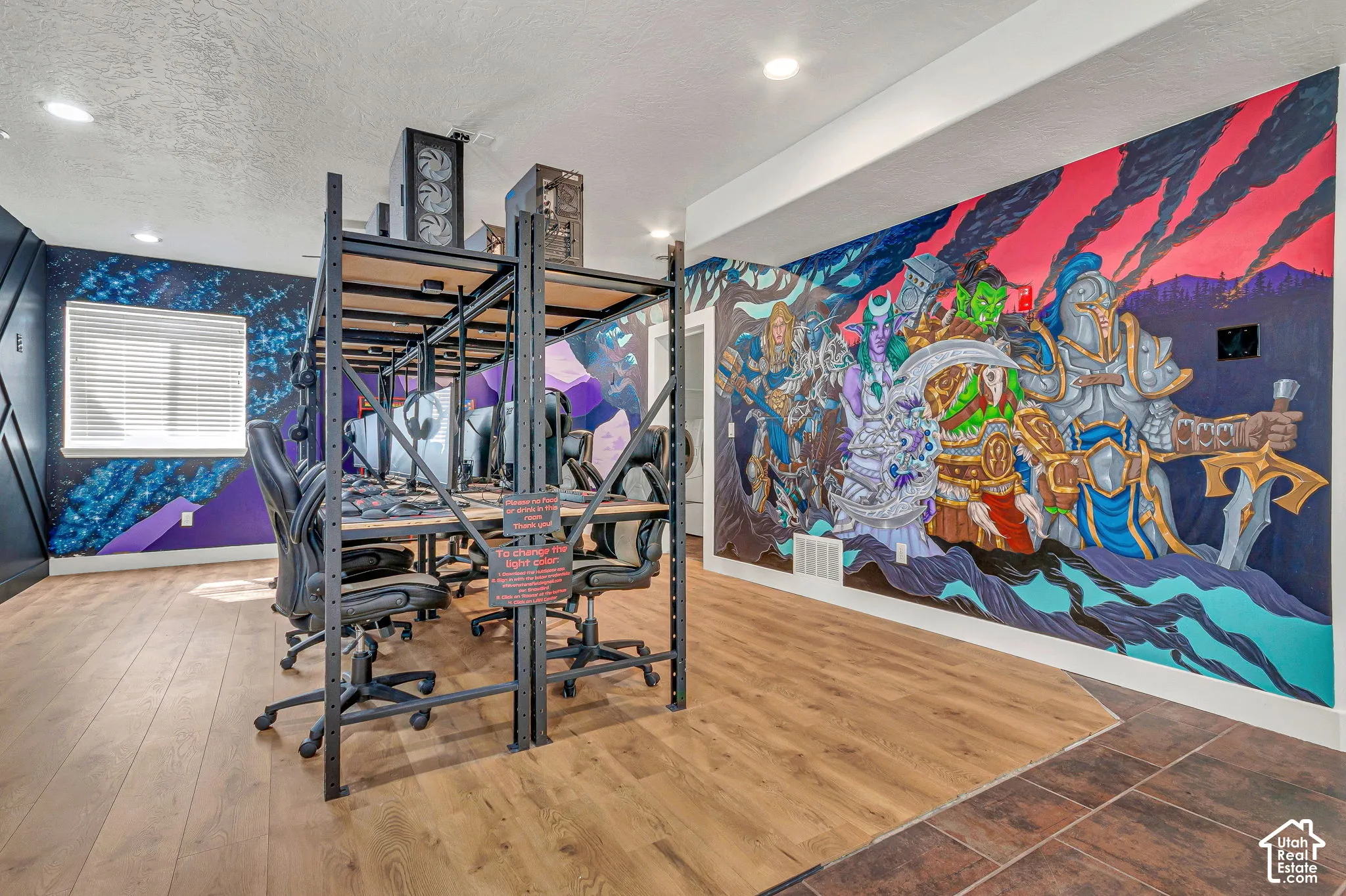 Room featuring wood-finish flooring, recessed lighting, horizontal blind window coverings, and a large-scale wall mural