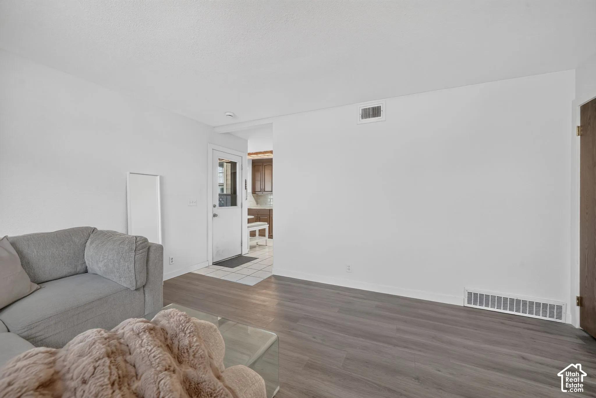 Interior space featuring wood-finish flooring and a white exterior door with glass pane inset