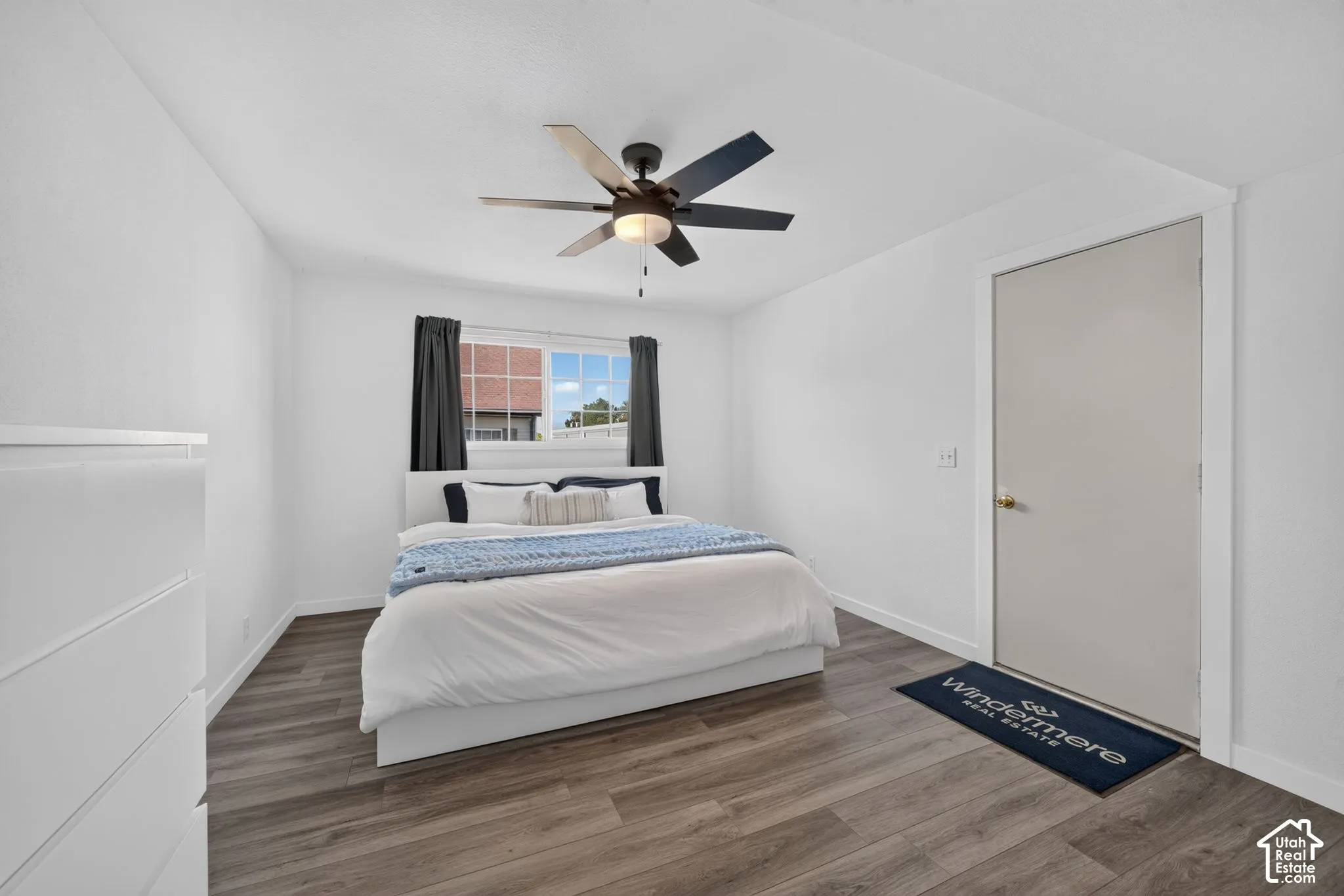 Primary bedroomLVP flooring, multi-blade ceiling fan with integrated lighting, and horizontal sliding window