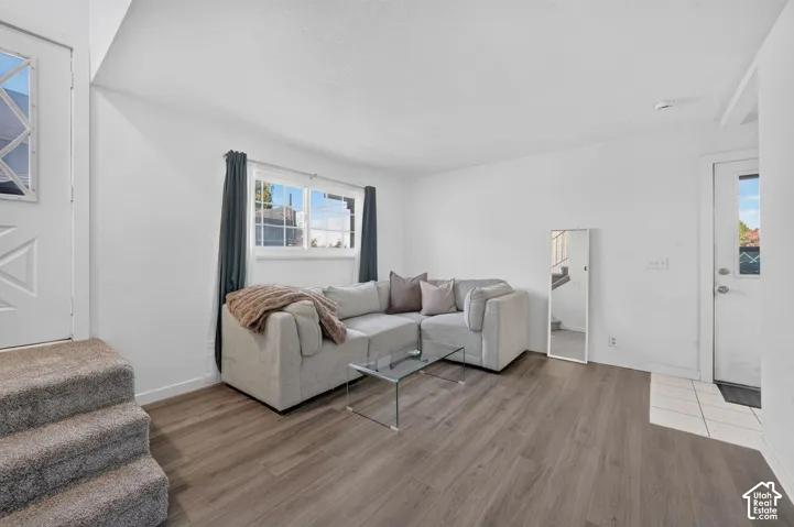 LVP flooring, white walls, dual exterior entry doors, and a horizontal sliding window