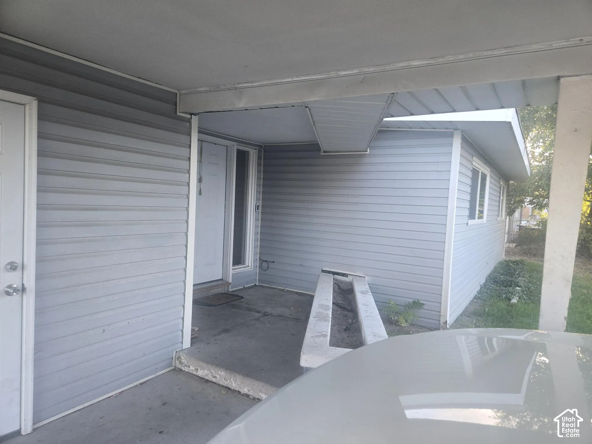 Covered entryway featuring horizontal siding, concrete porch flooring, and a built-in masonry planter