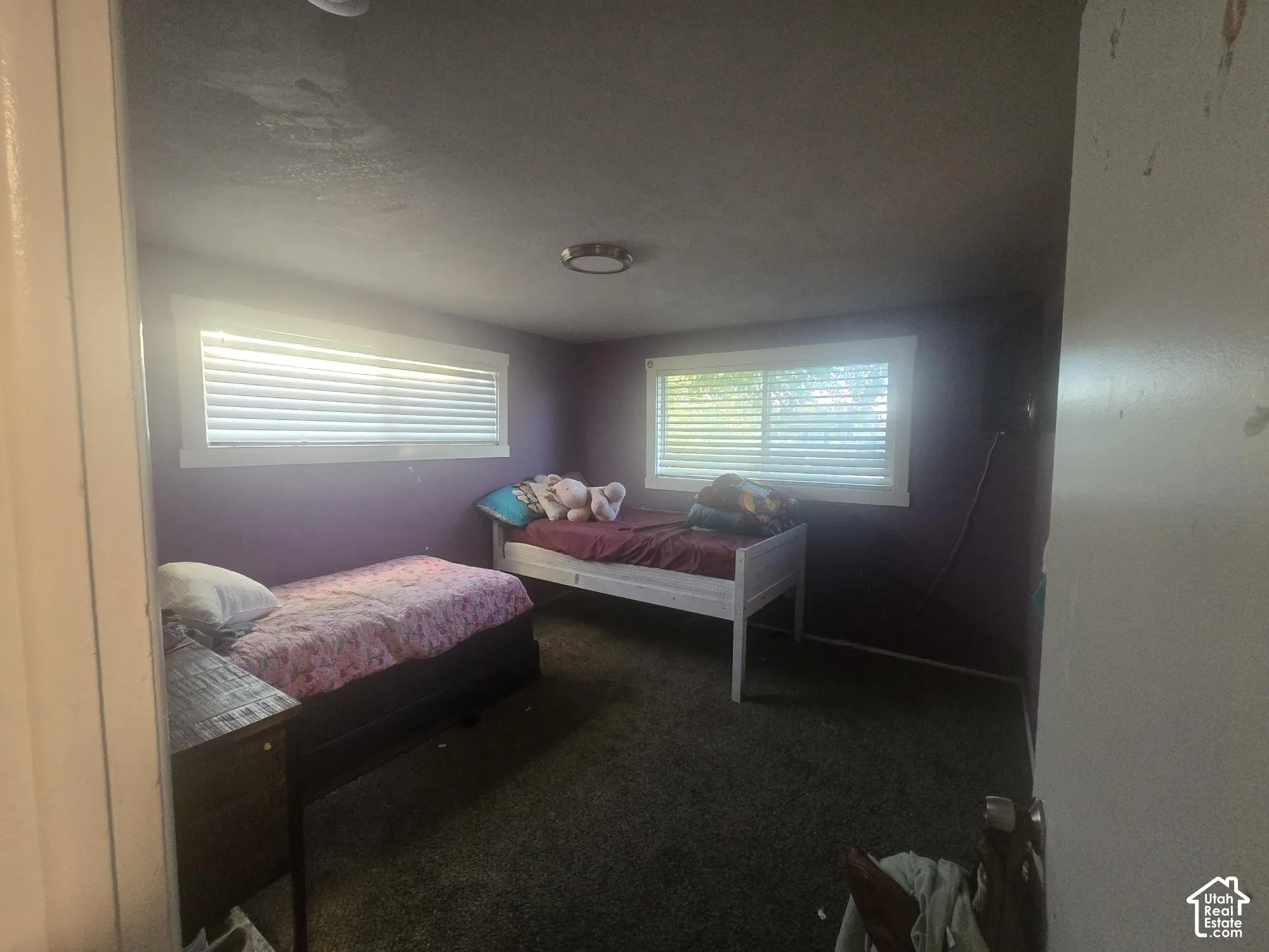 Interior room featuring wall-to-wall carpeting, two horizontal windows, and a flush-mount ceiling light fixture