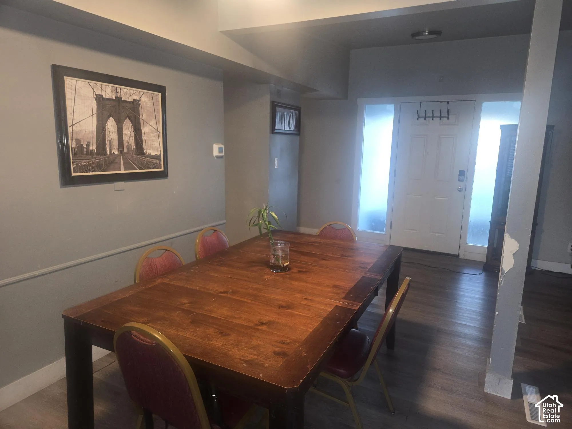 Entryway featuring wood-finish flooring, chair rail molding, and a white six-panel door with flanking frosted glass side panels