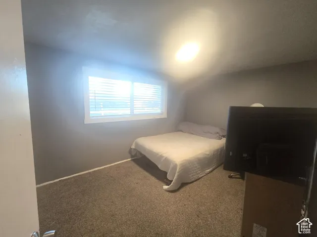 Interior room featuring neutral wall paint, carpeted flooring, and a window with horizontal blinds