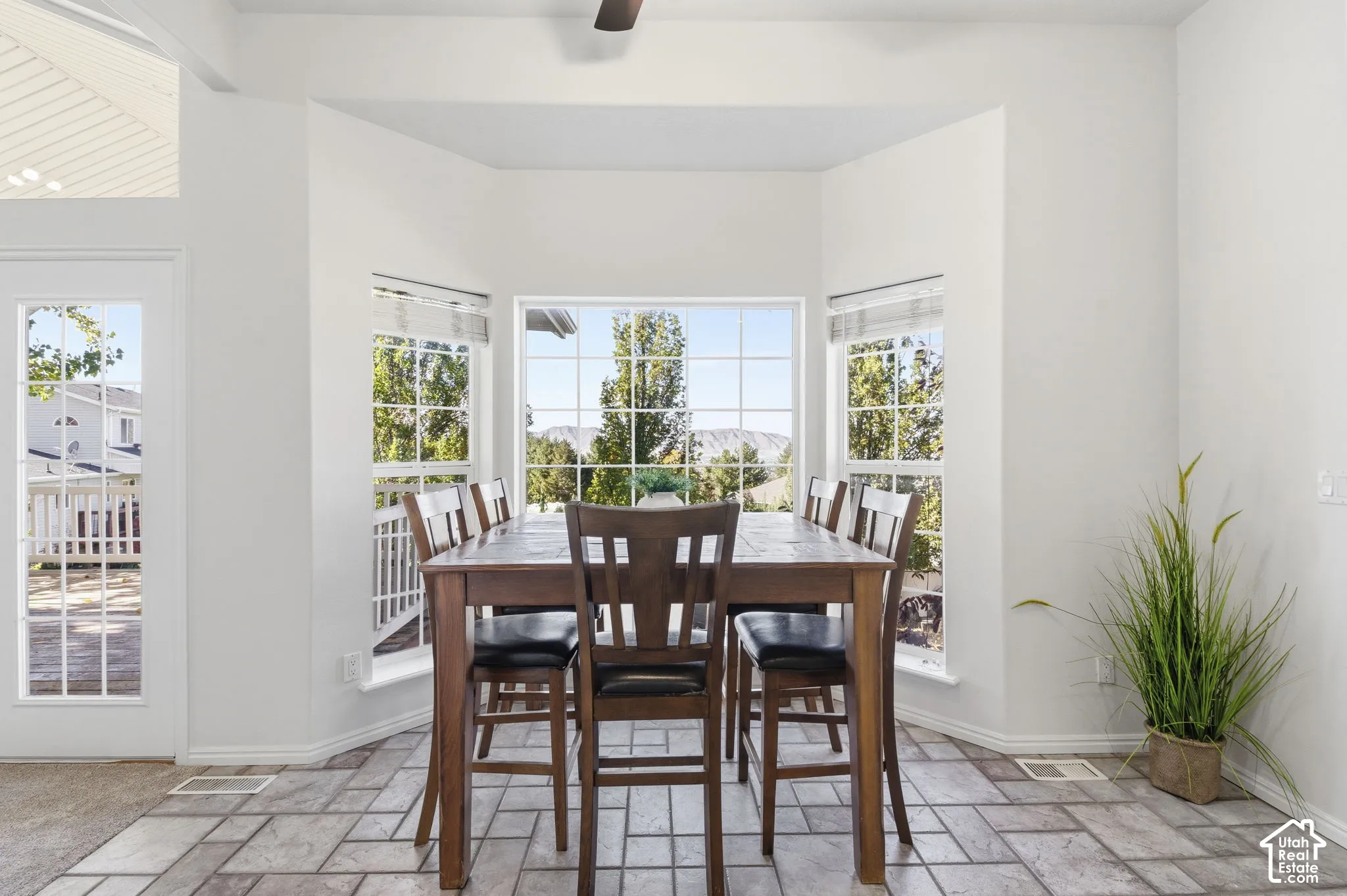 Bay window with multi-pane glass, tiled flooring, vaulted ceiling, and exterior door with glass panes
