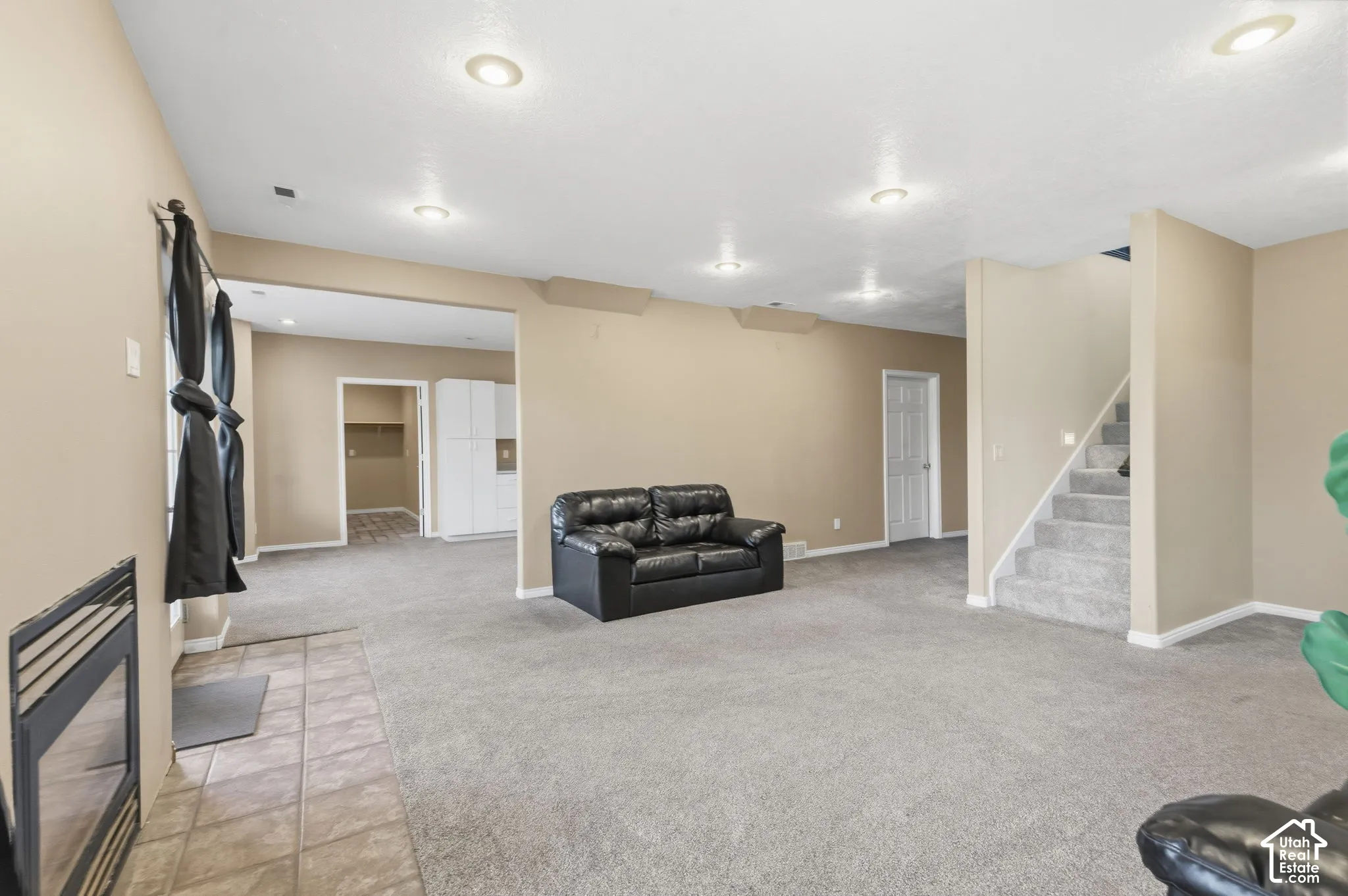 Interior space featuring recessed lighting, a built-in fireplace with a tile hearth, wall-to-wall carpeting, and a staircase with a handrail