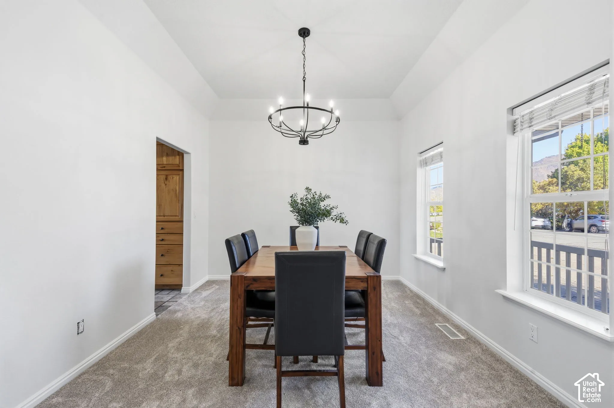 Tray ceiling, multi-light metal chandelier, and double-hung windows