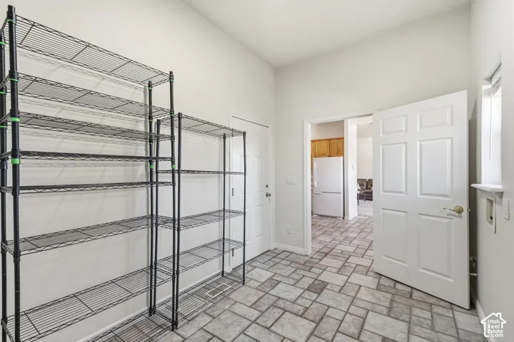 Tiled flooring with a stone-finish pattern, high ceilings, white six-panel doors, and a window with a sill