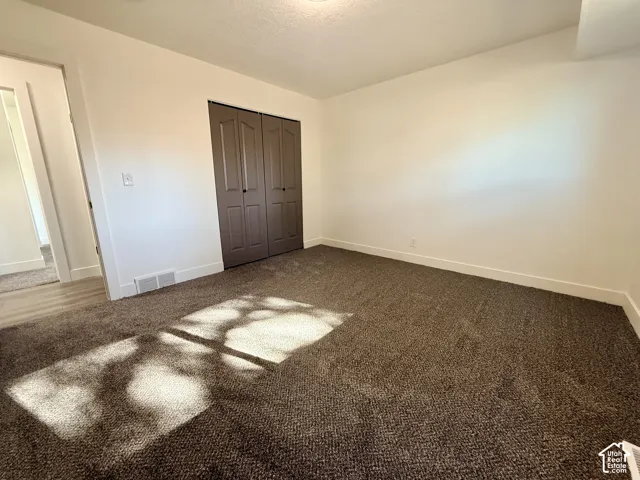 Neutral-toned wall paint, plush carpeting, and double-panel doors featuring dark finish hardware
