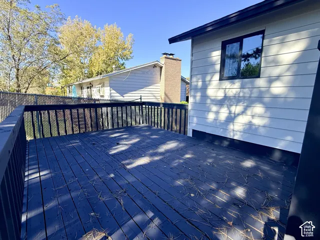 Raised exterior deck featuring dark-finish wood decking, perimeter railings, and horizontal lap siding