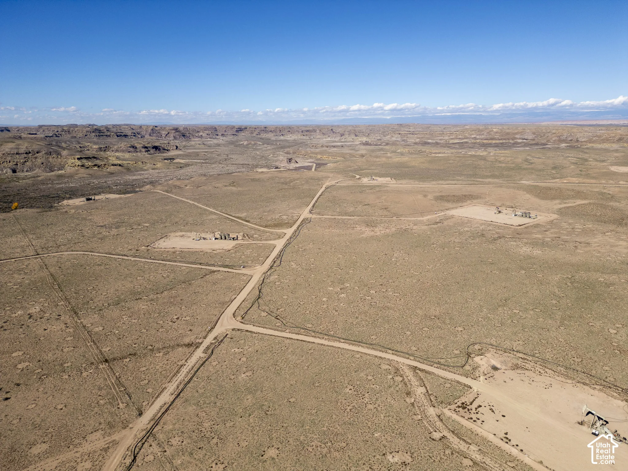 Expansive acreage featuring rugged desert terrain, natural scrub brush vegetation, and established dirt access roads