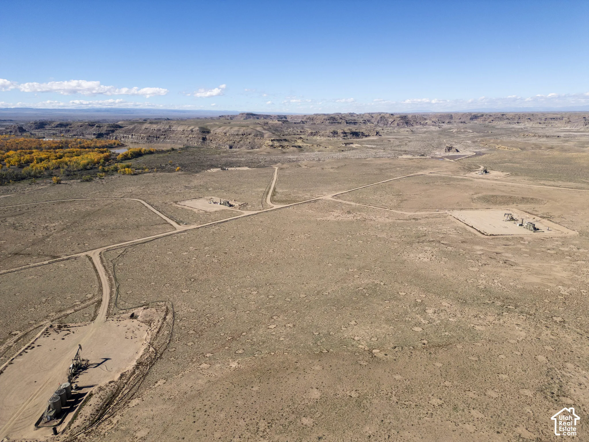 Expansive desert acreage featuring established dirt access roads, prominent natural topography, and distant mountain backdrops