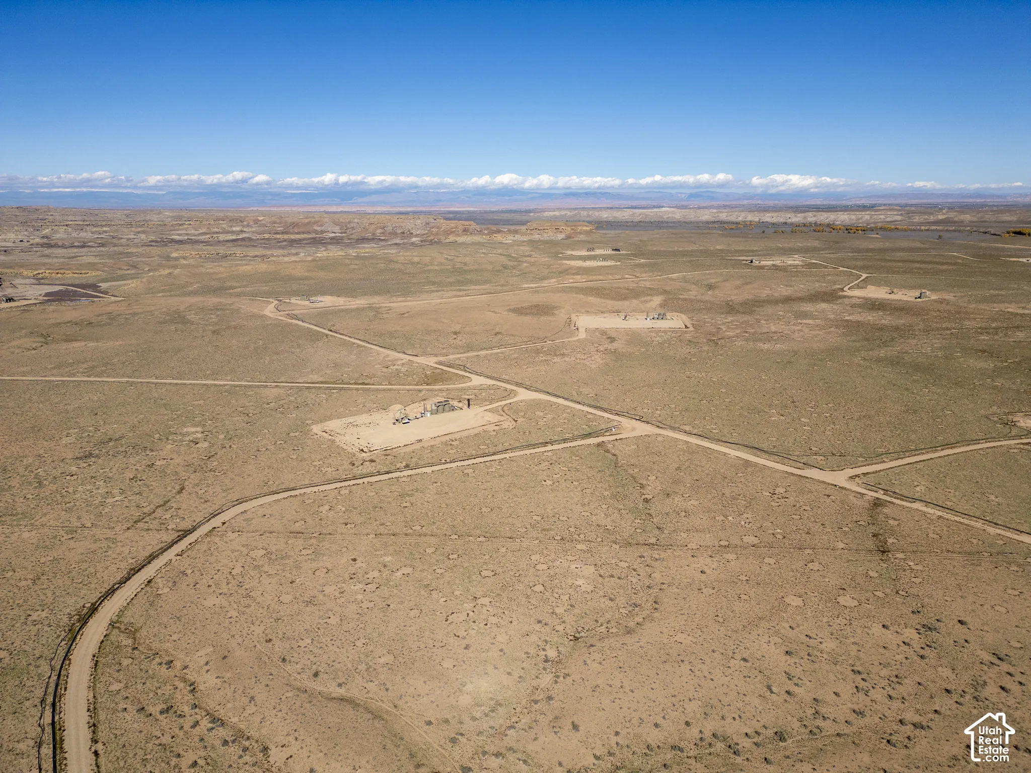 Expansive desert acreage featuring natural terrain, dirt-surface access roads, and mountainous horizons