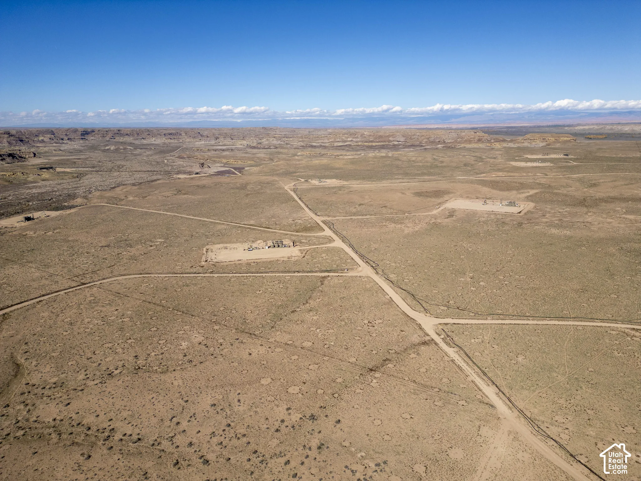 Expansive acreage featuring unpaved road access and prominent high desert terrain under a clear sky