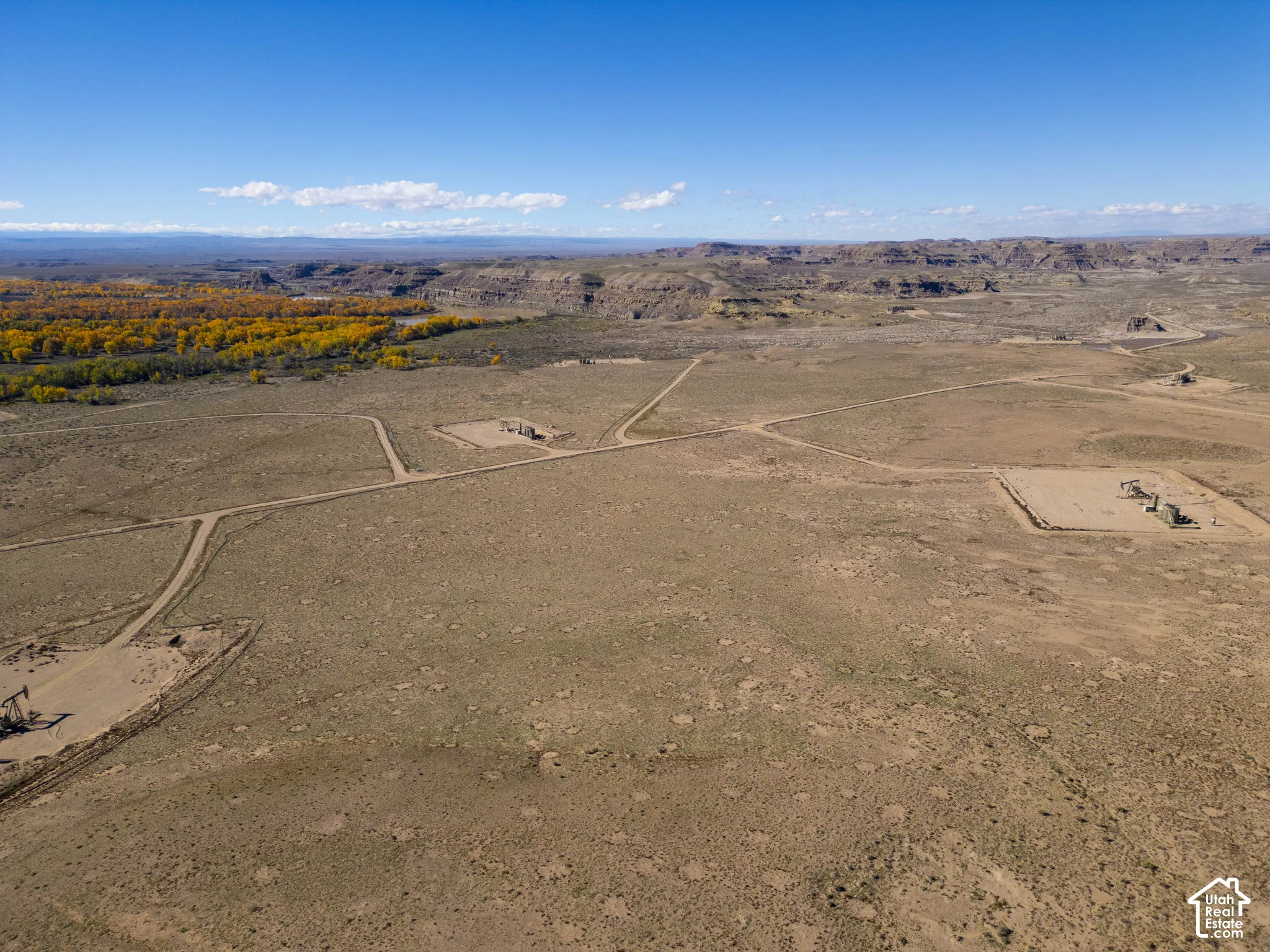 Expansive desert acreage featuring unpaved access paths, level terrain, and a backdrop of mountain ranges