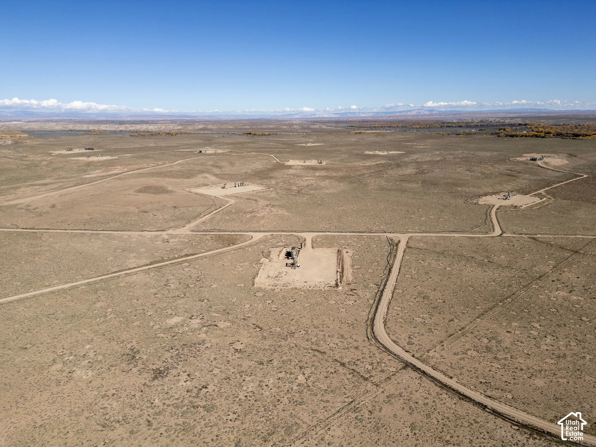 Expansive acreage featuring established dirt roads, natural high-desert topography, and prominent mountain ranges on the horizon