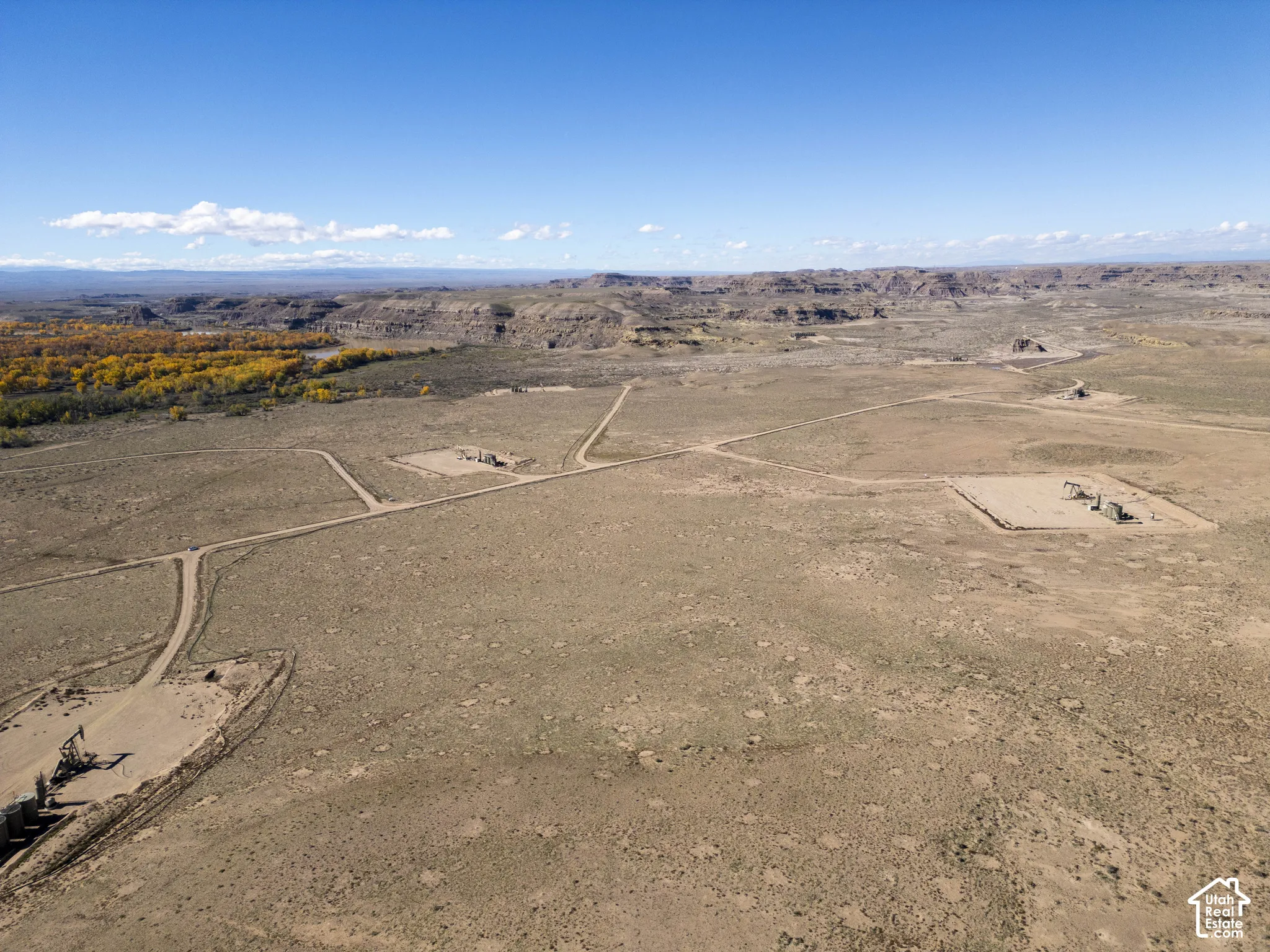 Expansive high-desert acreage featuring established dirt access roads, industrial utility infrastructure, and surrounding mountain topography