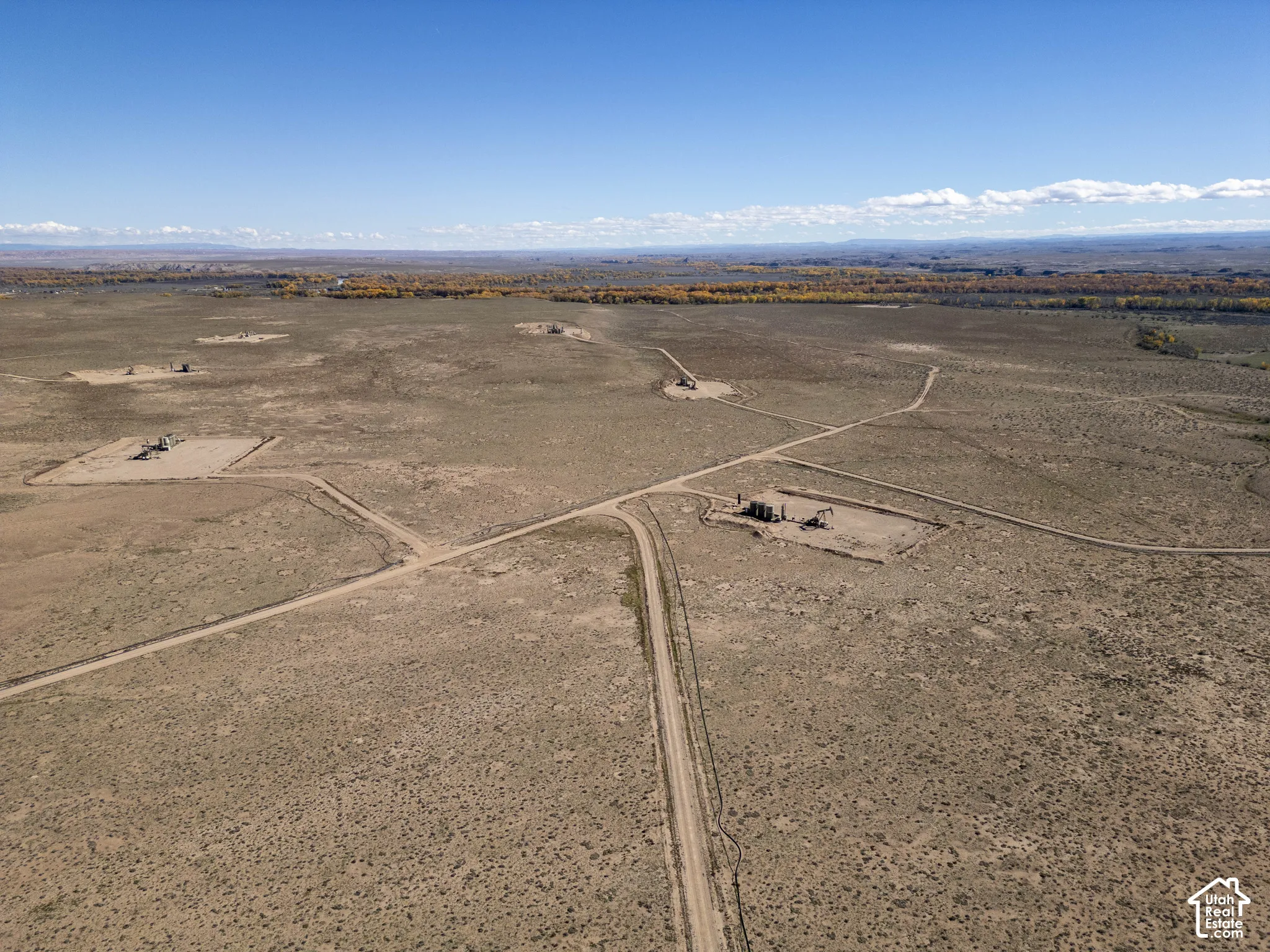 Expansive acreage featuring unpaved access roads, open desert terrain, and distant horizon scenery