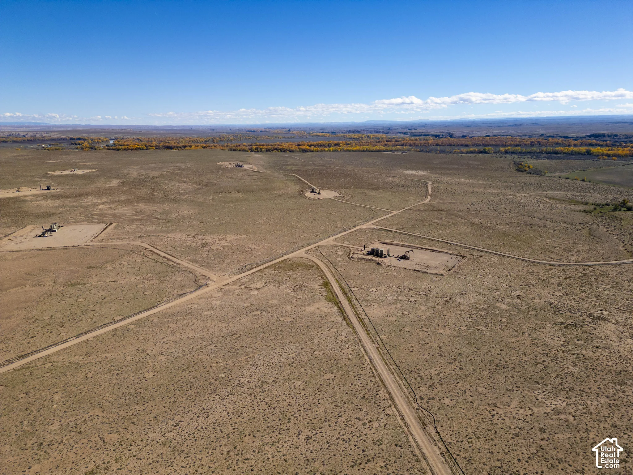 Expansive desert acreage featuring natural terrain, dirt access paths, and panoramic horizon scenery