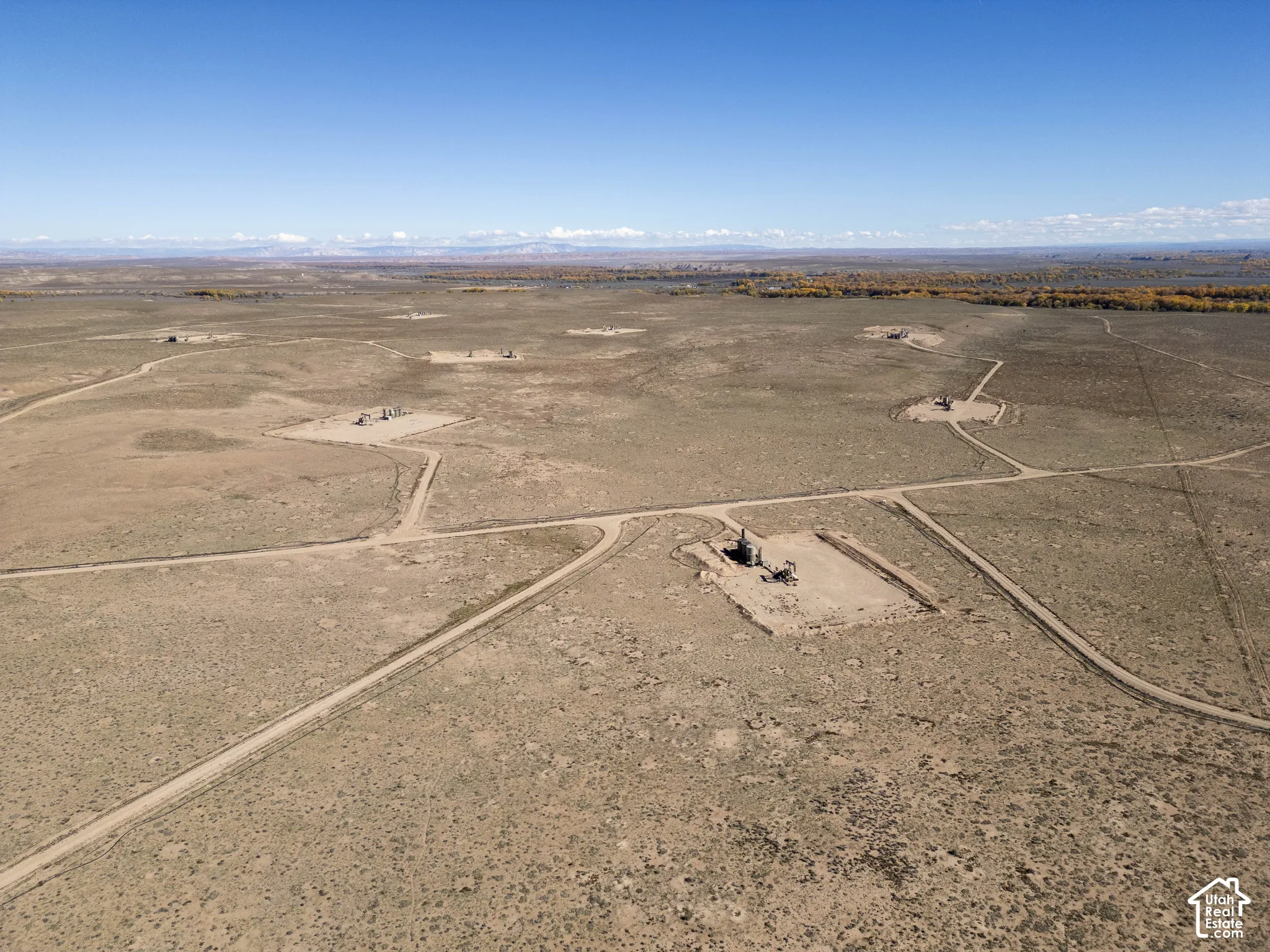 Expansive acreage featuring unencumbered terrain, established gravel access roads, and mountain range backdrop