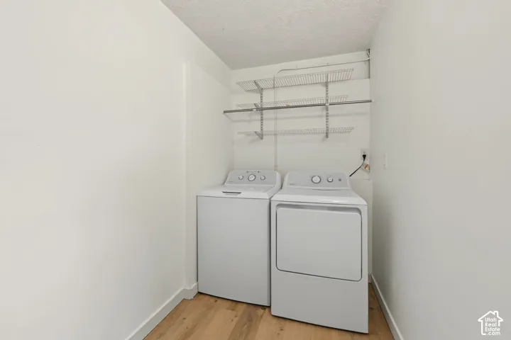 Dedicated utility area featuring wood-finish flooring and wall-mounted wire shelving