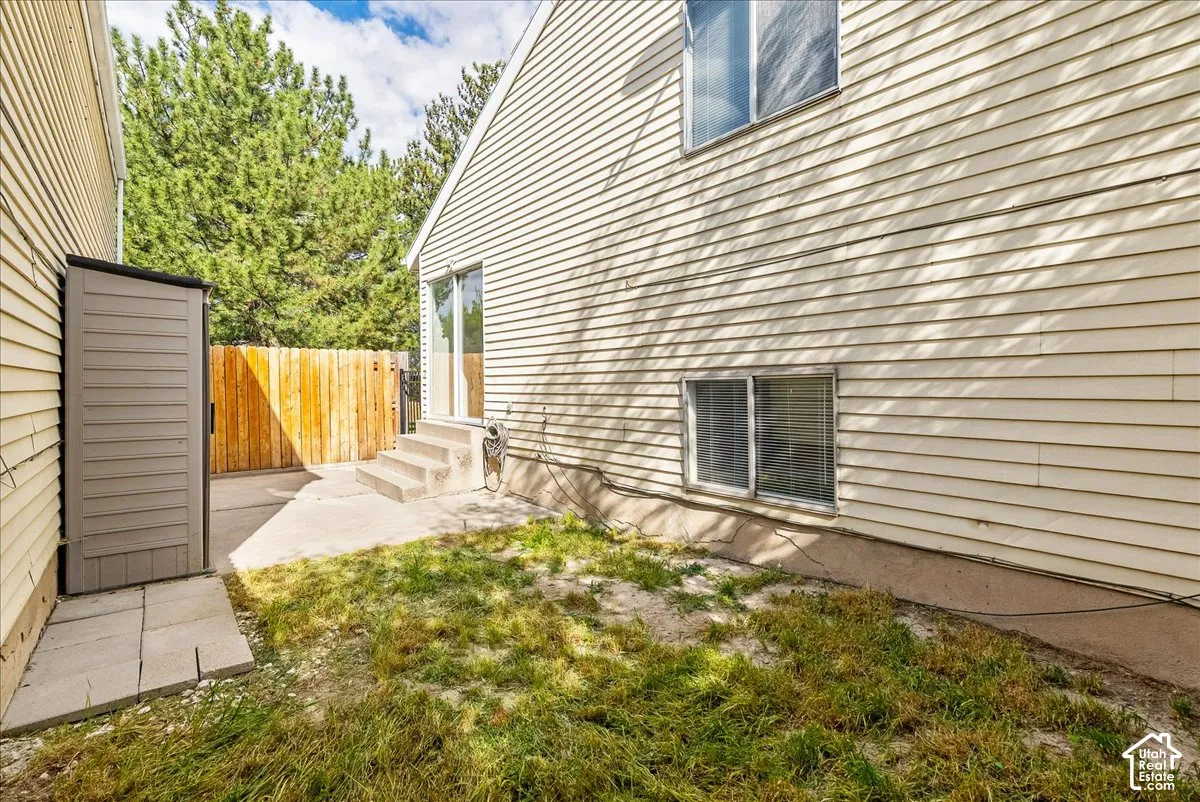 Exterior siding, concrete patio, sliding glass door, and wood privacy fencing