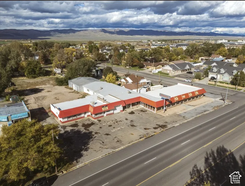 Commercial property featuring parking lot in front of building and main street.