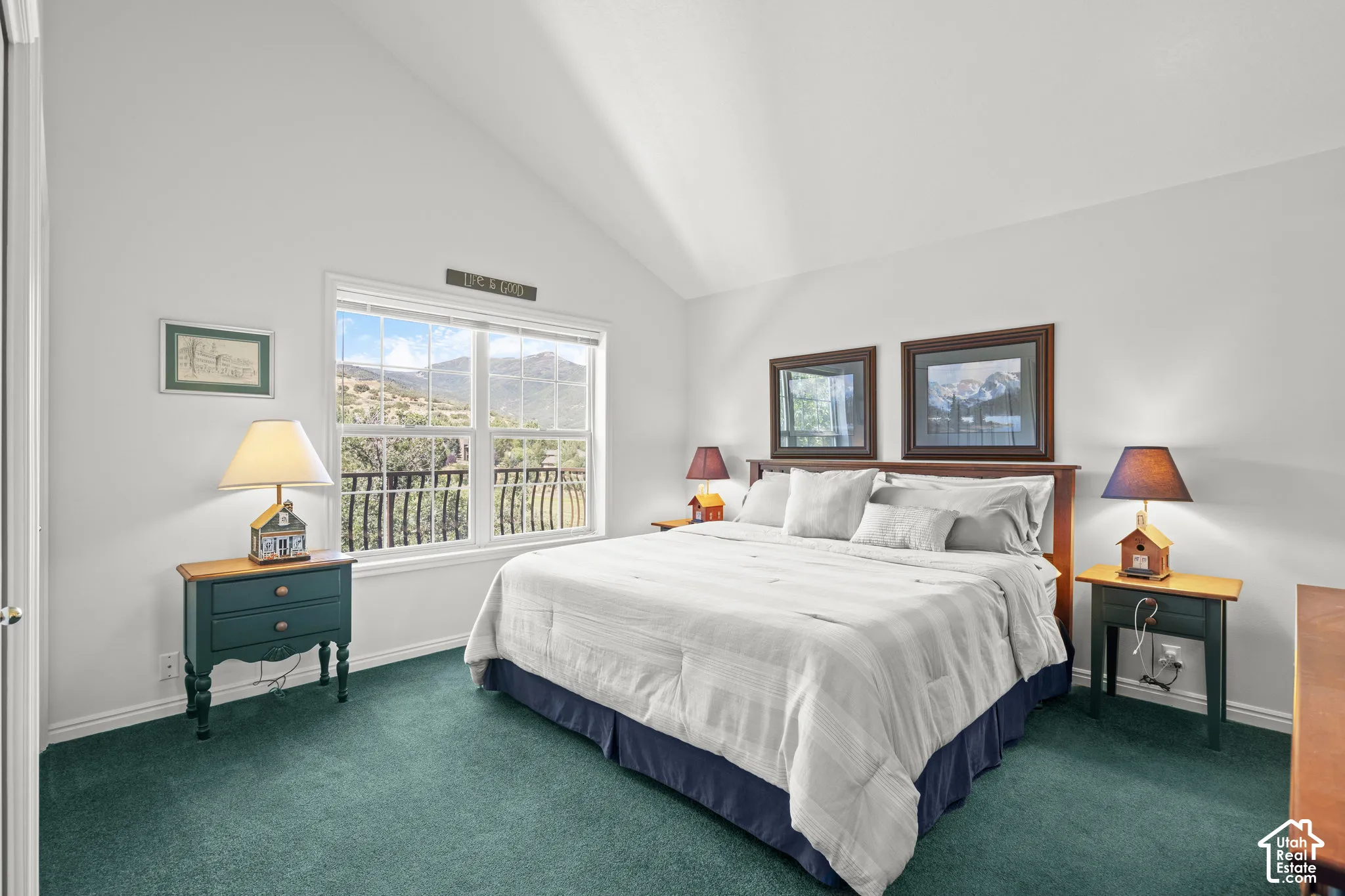 Vaulted ceiling, wall-to-wall carpeting, and a dual-pane window featuring a mountain backdrop