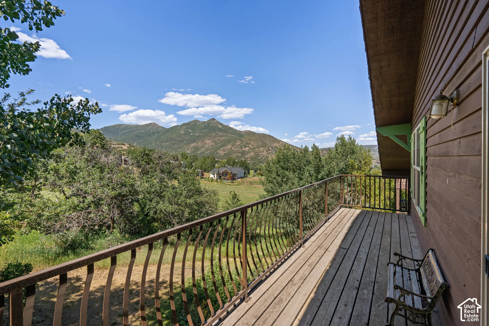 Elevated wooden deck featuring metal balustrades and mountain scenery
