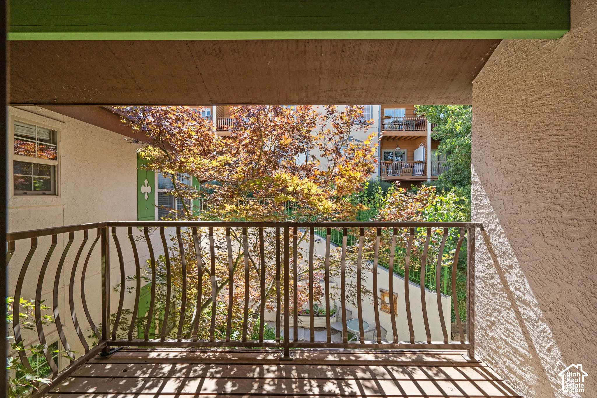Private balcony featuring metal railings and wood-tone deck flooring