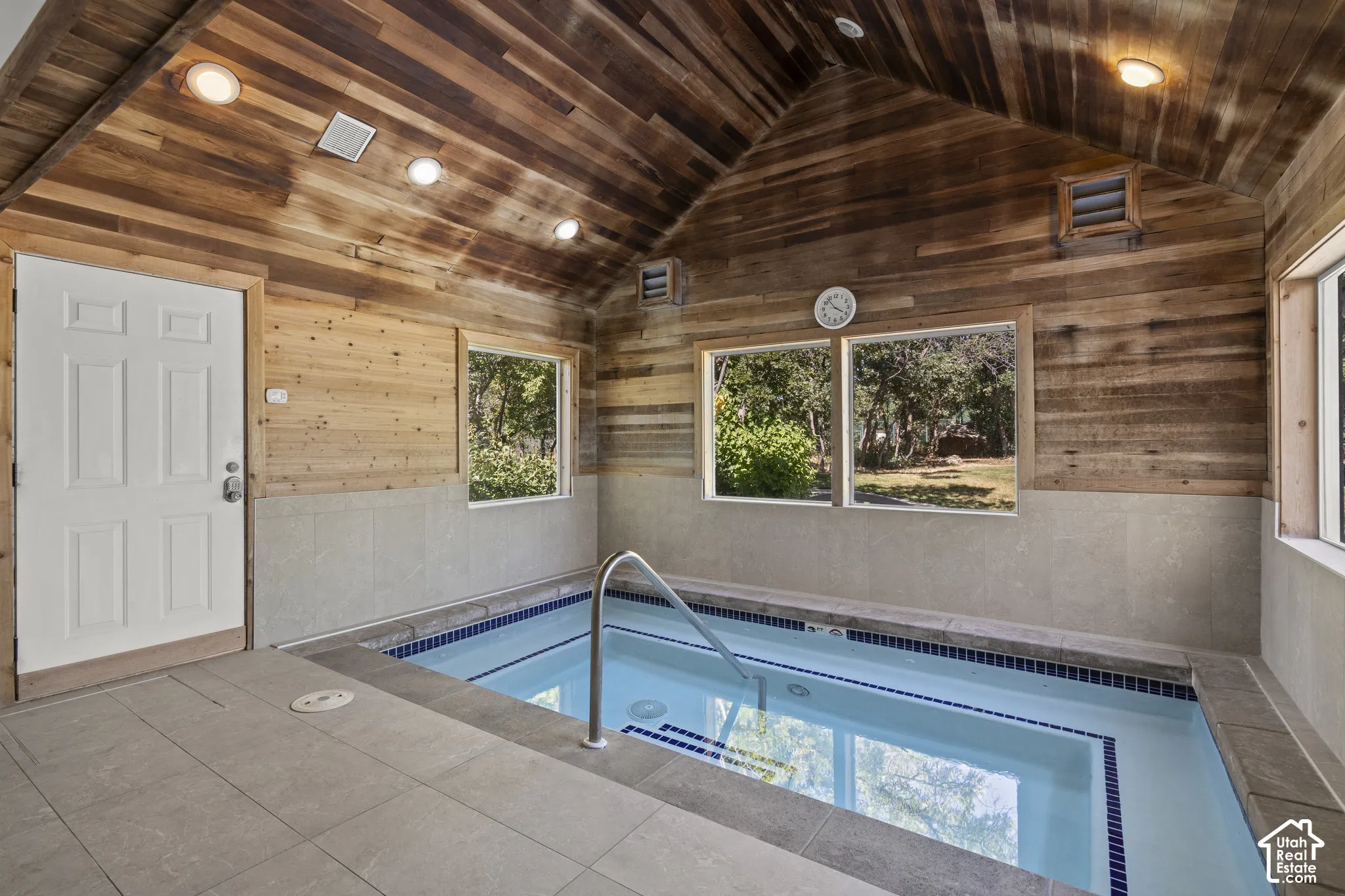 Indoor pool room featuring vaulted wood-plank ceilings, recessed lighting, tile surround flooring, and large windows