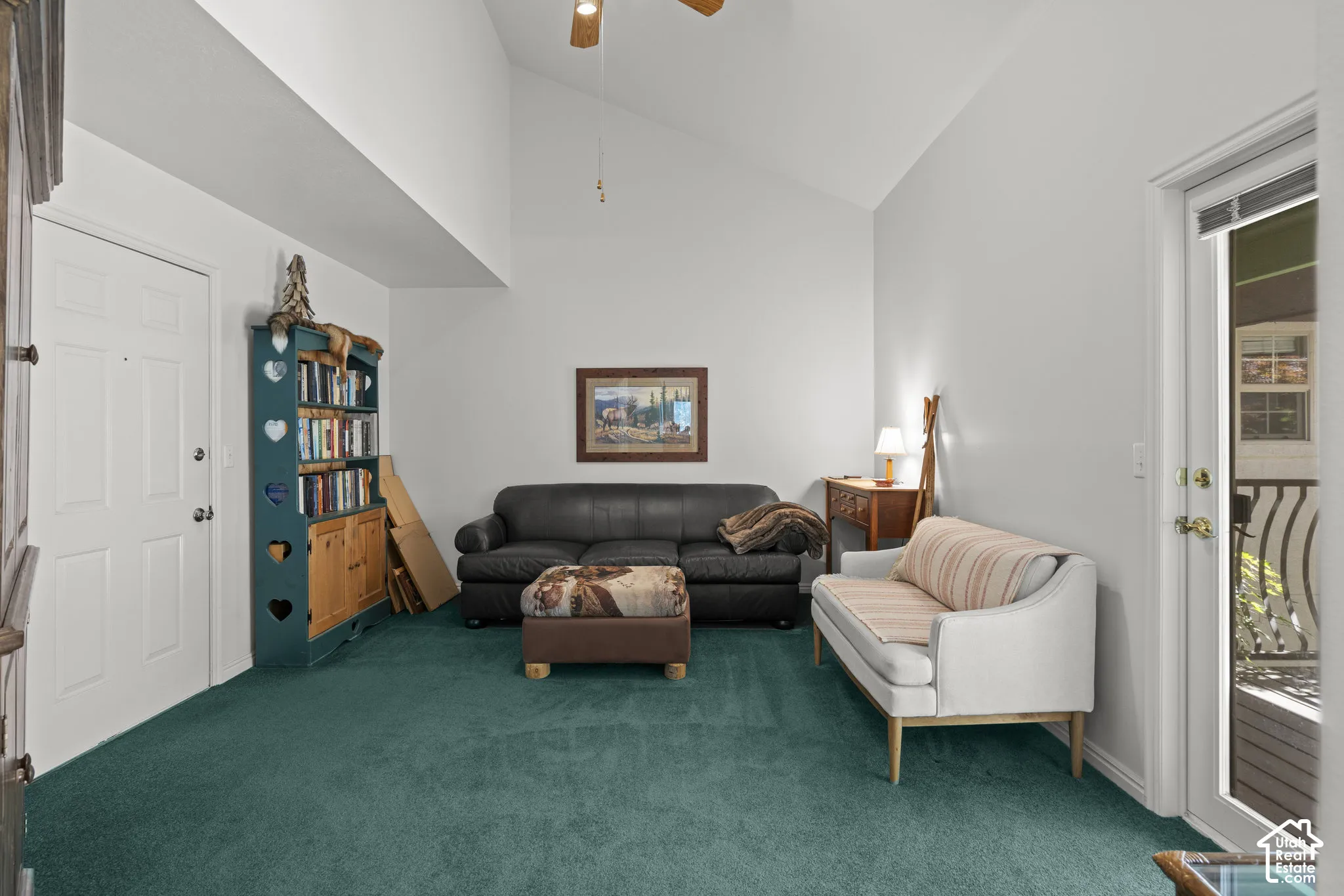 Vaulted ceilings featuring a central ceiling fan and a glass-paneled exterior door