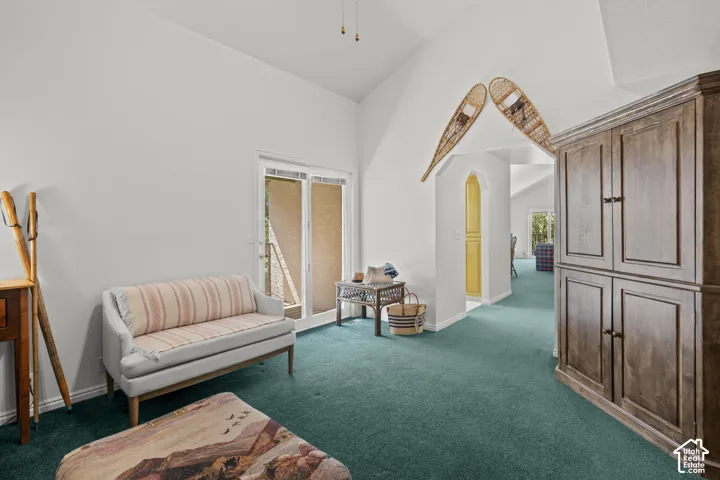 Vaulted ceilings featuring a ceiling fan, dual-pane glass sliding door, and floor-to-ceiling wooden built-in cabinetry