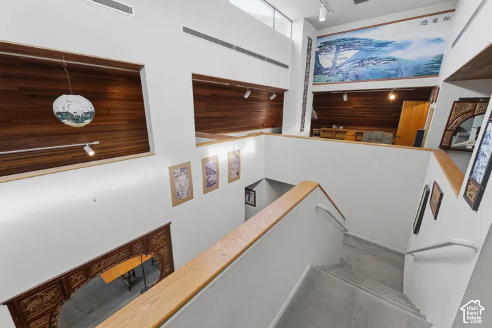 Double-height ceiling, wood-plank wall paneling, built-in recessed wall niches, and custom intricate woodwork trim