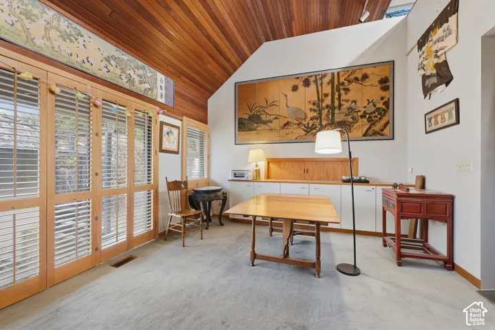 Vaulted wood-plank ceiling, floor-to-ceiling glass panel doors with integrated shutters, and custom built-in cabinetry featuring wood shelving