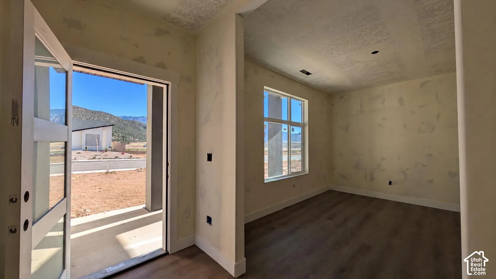 Interior space featuring wood-finish flooring, a multi-pane window, and an exterior door with rectangular glass inserts