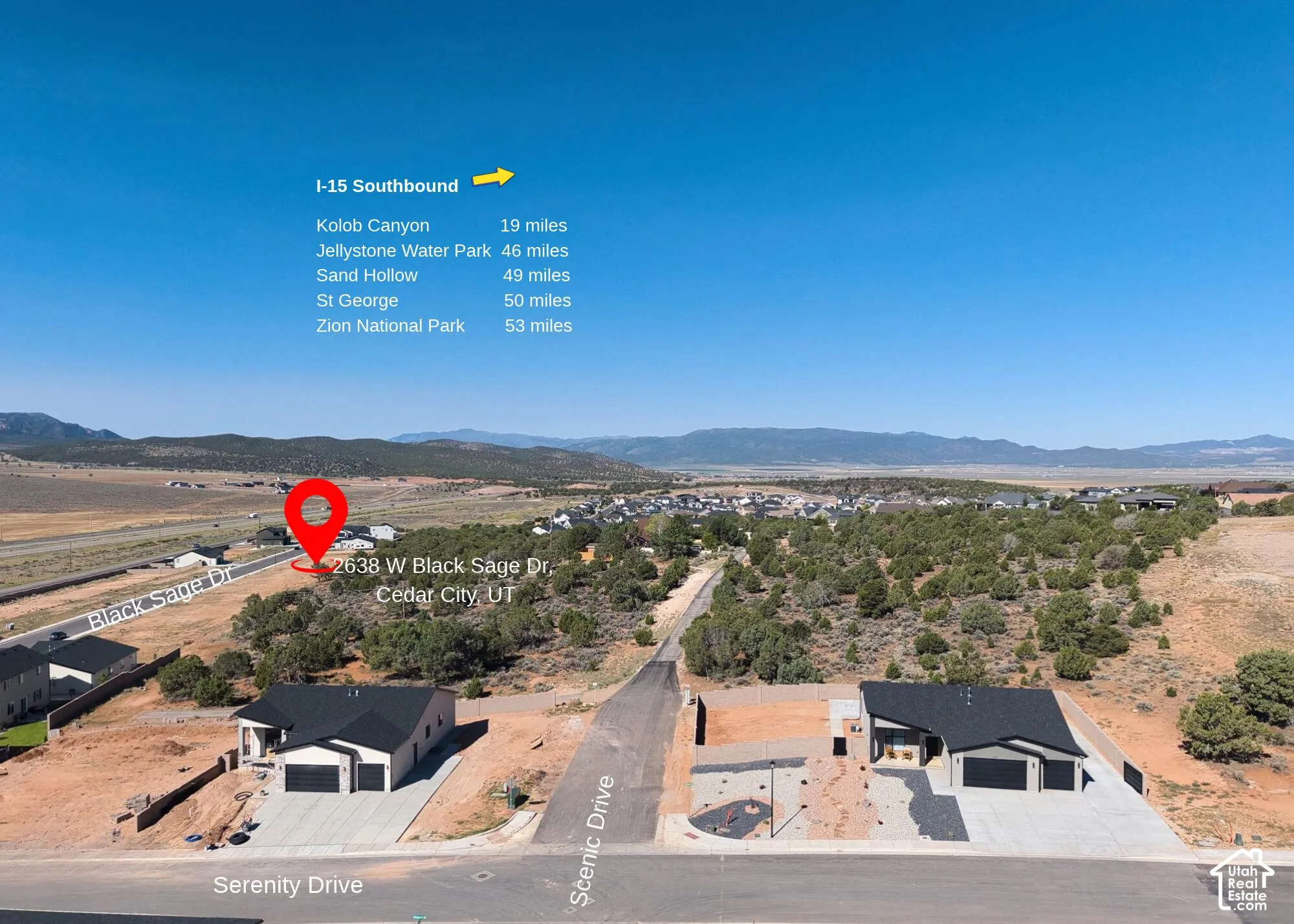 Aerial perspective of a corner lot property featuring asphalt driveway access, concrete garage aprons, and expansive desert landscape