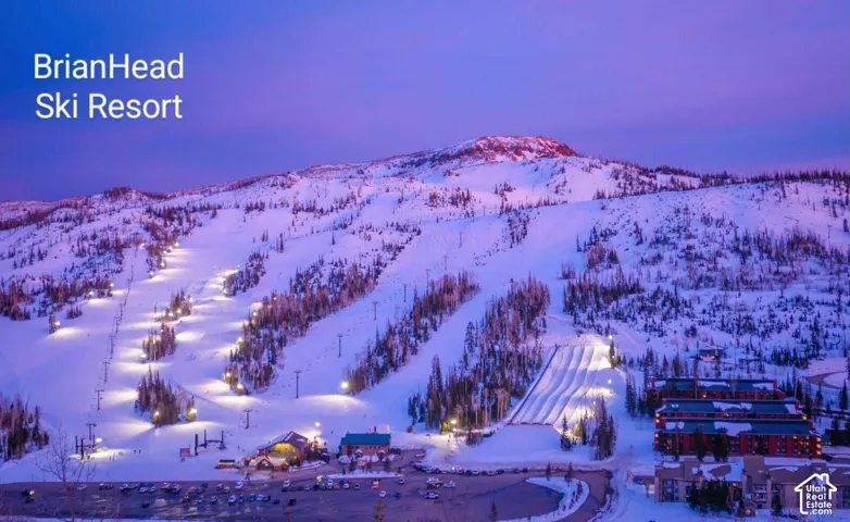Aerial perspective of the Brian Head Ski Resort featuring snow-covered mountain terrain, cleared ski slopes, mechanical lift infrastructure, and coniferous forest landscape