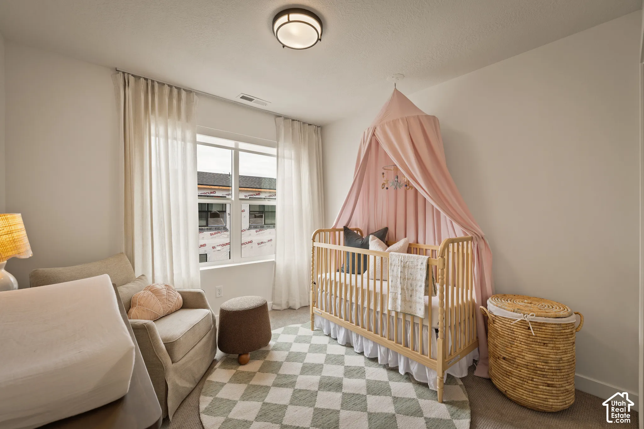 Neutral-toned room featuring a window with natural light, flush-mount ceiling lighting, and carpeted flooring